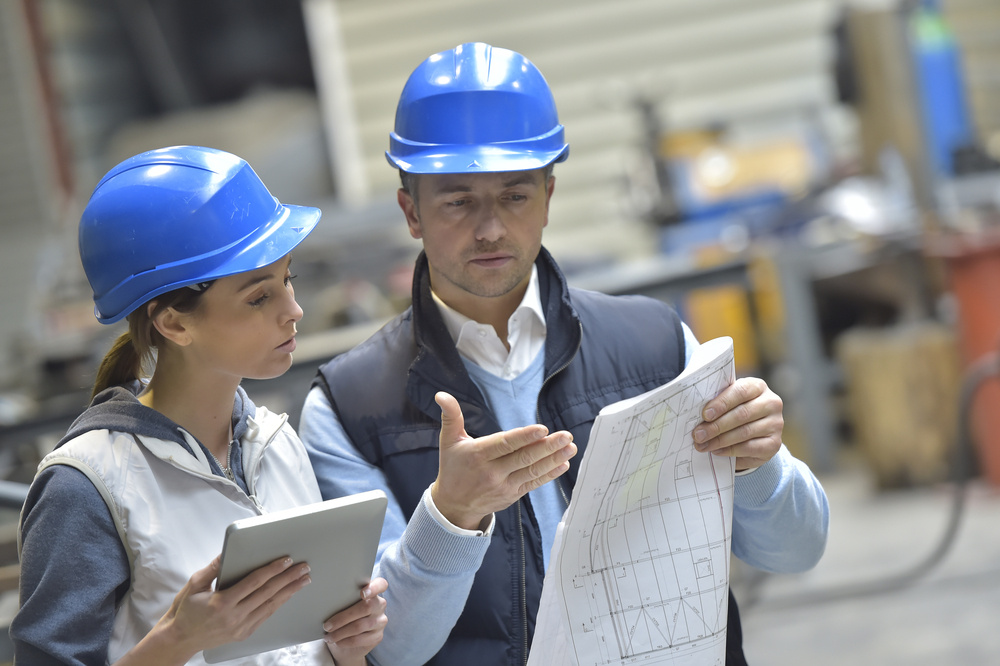 Engineers in mechanical factory reading instructions-4